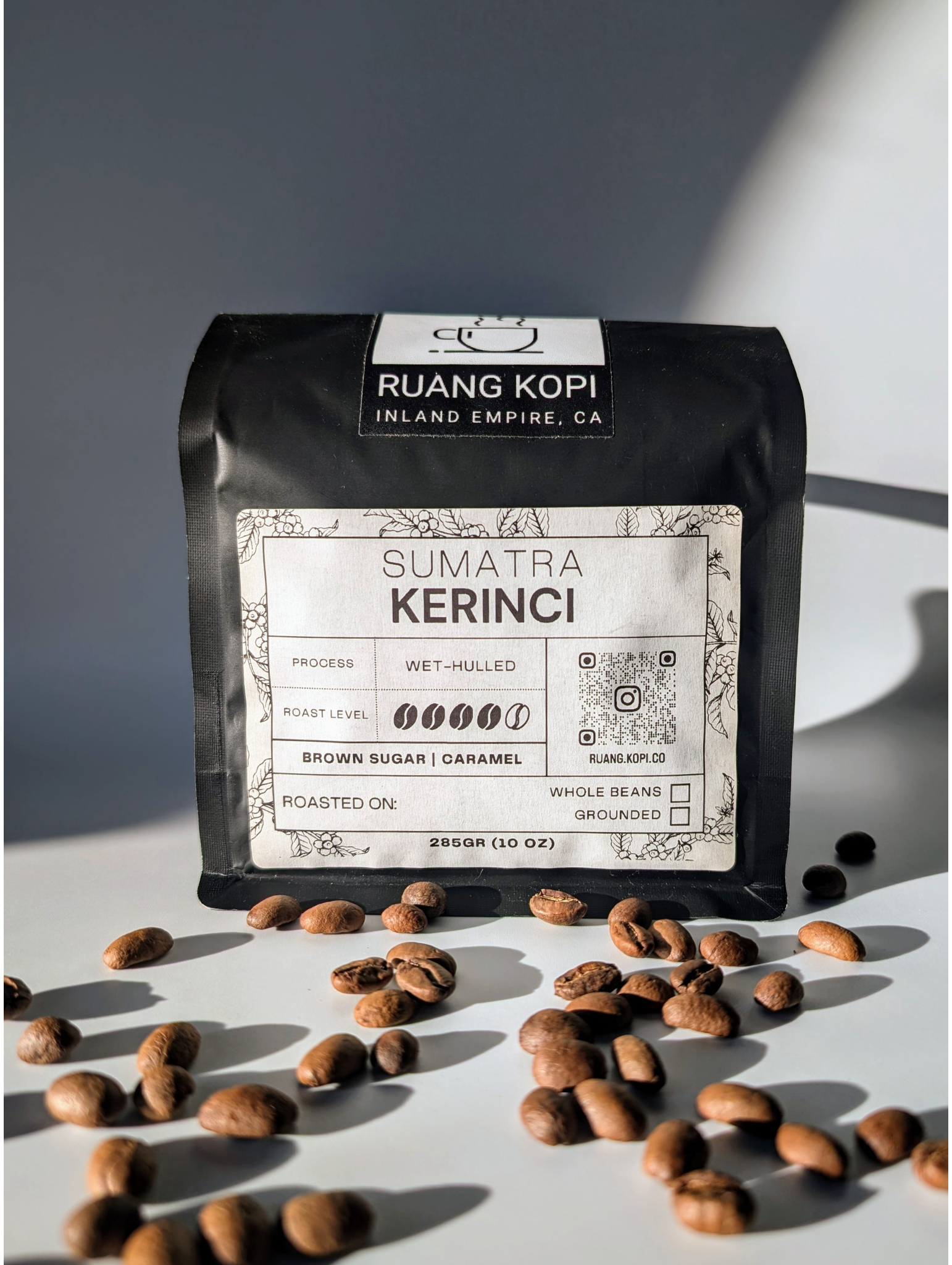 Sumatra Kerinci Gunung Tujuh roasted coffee from Ruang Kopi Roastery, single origin specialty coffee. Captured in studio setting with white background, golden hour lighting for an editorial style presentation. Perfect for premium coffee enthusiasts.