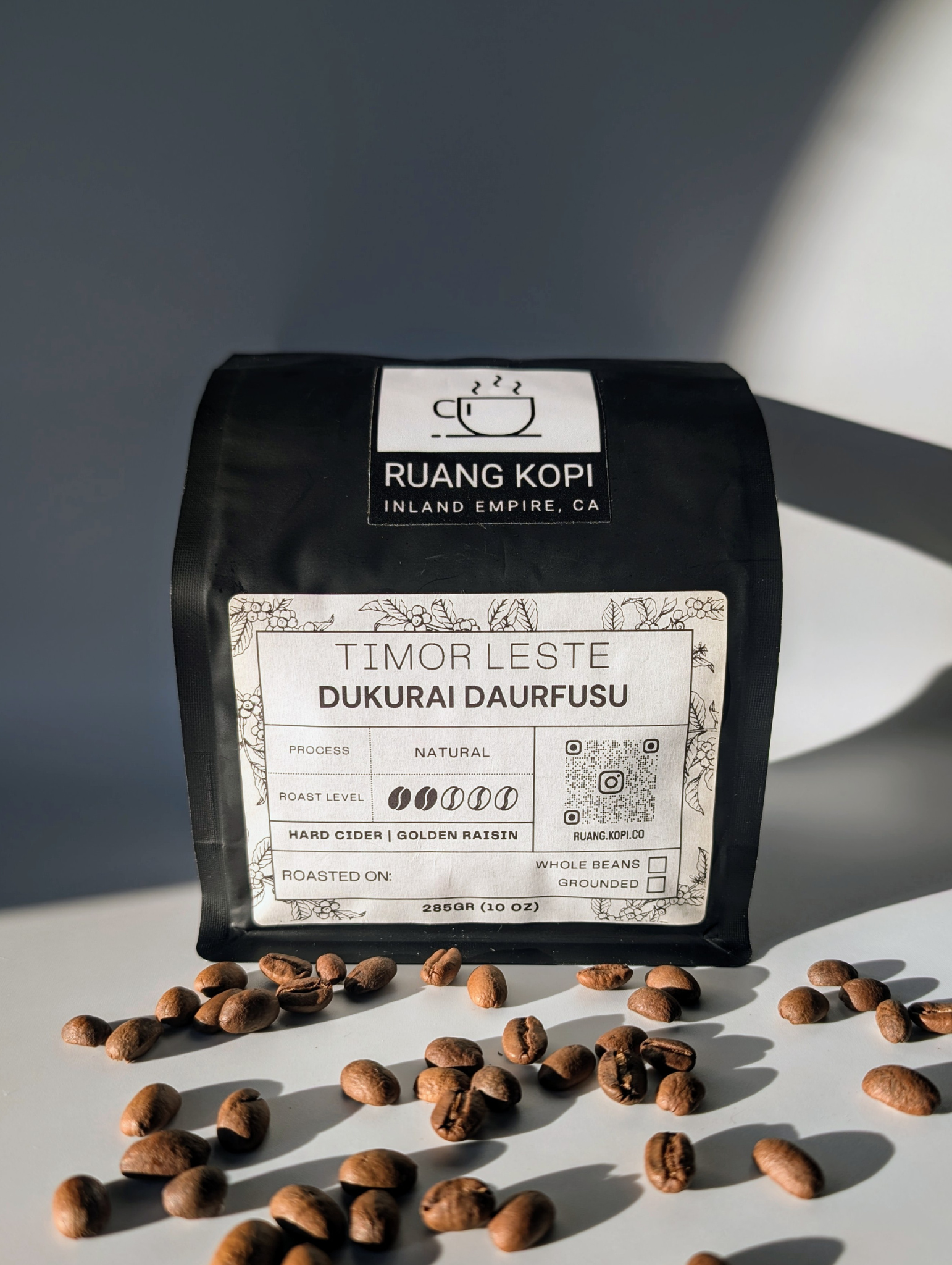 Timor Leste Dukurai Daurfusu roasted coffee from Ruang Kopi Roastery on a white background. Captured in golden hour lighting, this studio product photo highlights the quality of single origin specialty coffee, emphasizing its premium attributes.